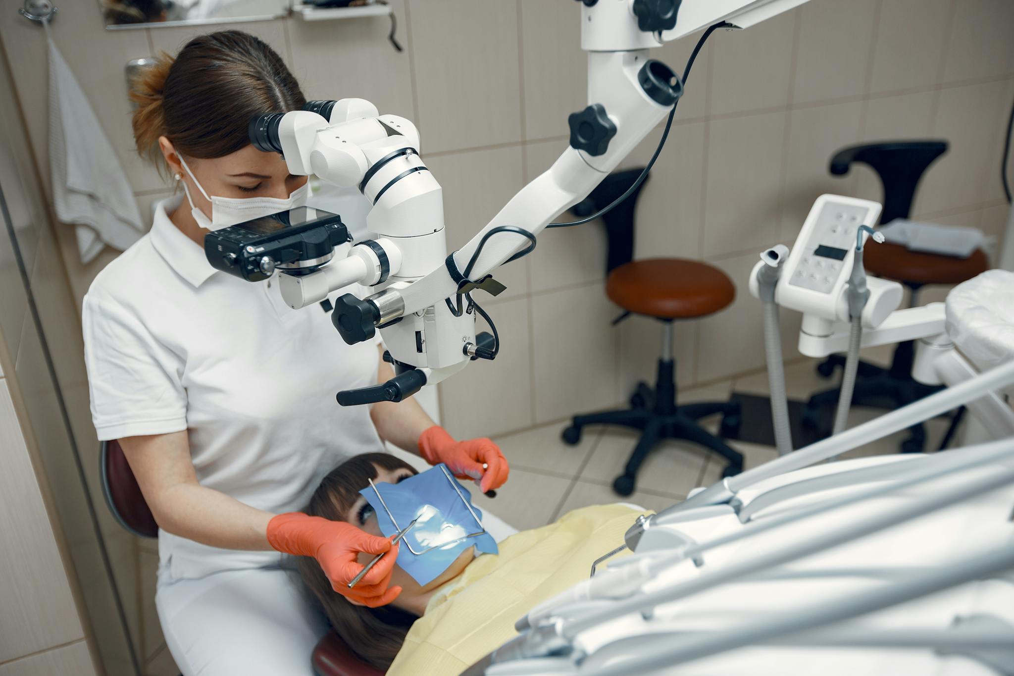 Dentist using advanced microscope for precise dental treatment in clinic.